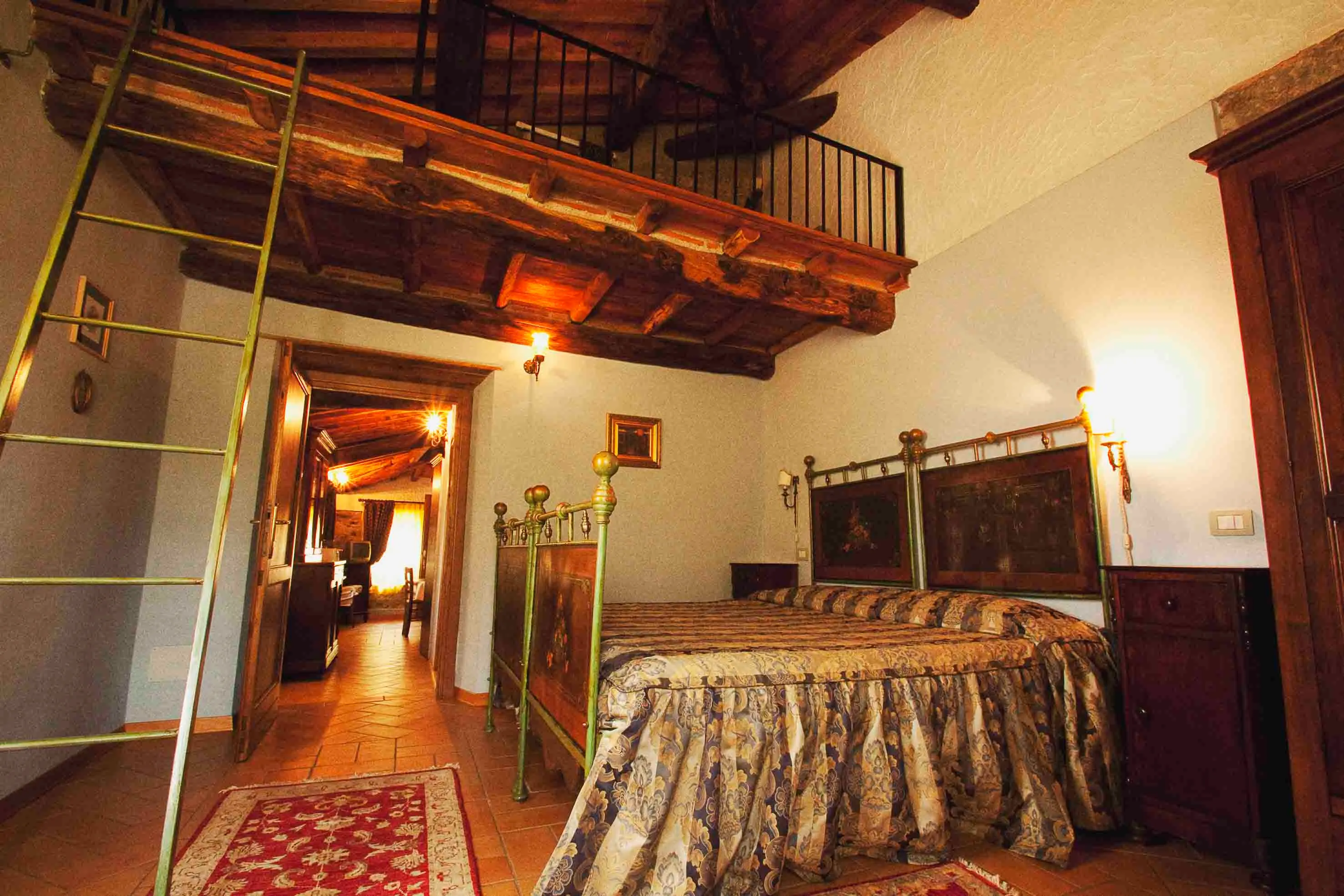 Camera dell’Amelia con soppalco in legno e letto in ferro battuto