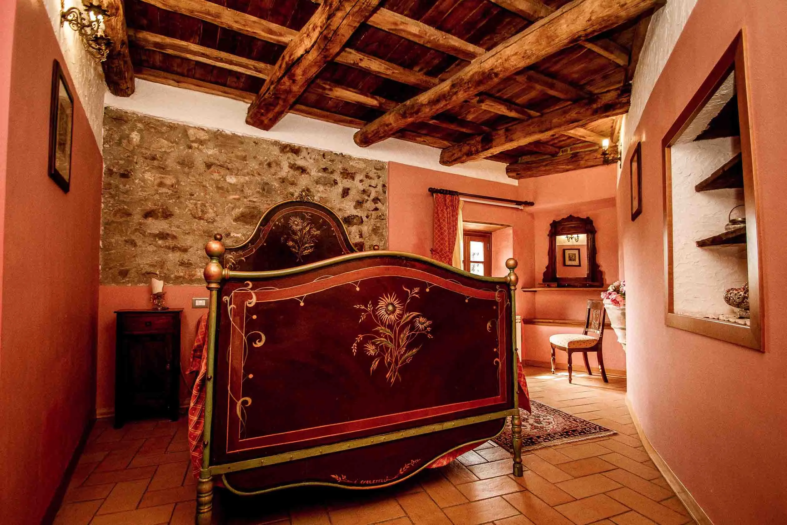 Camera dell’Oreste con letto antico decorato e soffitto a travi